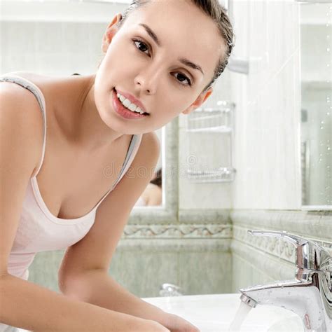 mujer joven que se lava la cara con el agua potable imagen de archivo imagen de pureza humano