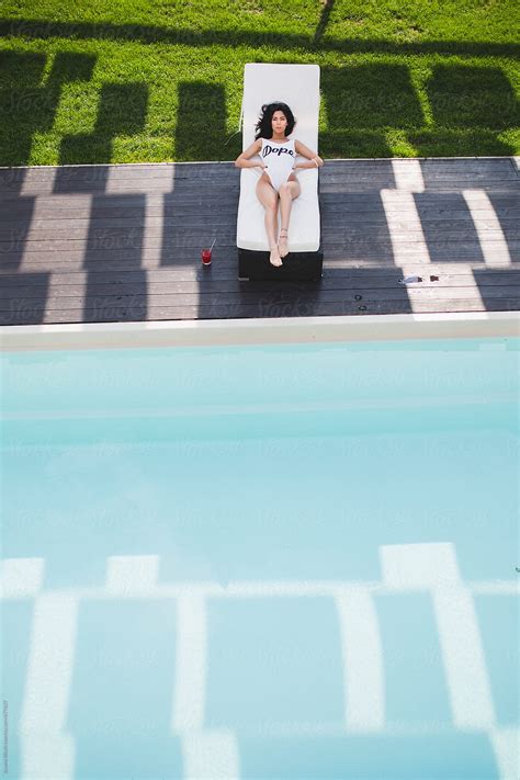 Beautiful Young Woman Sunbathing At The Pool By Stocksy Contributor