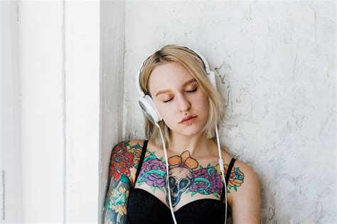 girl with tattoos listen to music by stocksy contributor alexey kuzma stocksy
