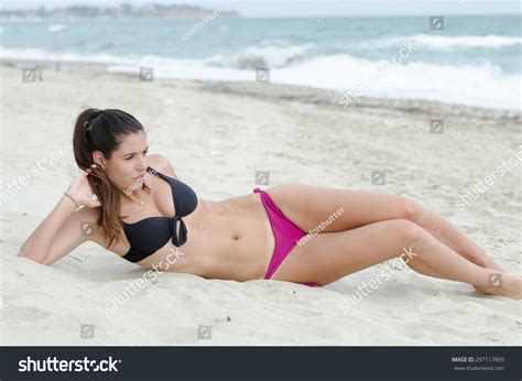 Sexy Athletic Women In Bikini Lying Down On Sand Ocean As Background