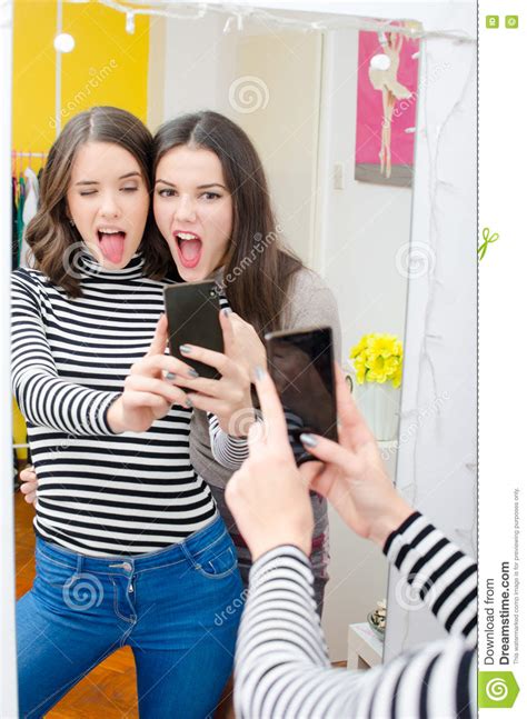 deux belles adolescentes prenant des selfies tout en faisant des visages image stock image du
