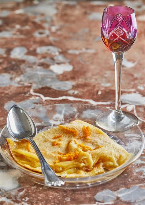 Pancakes With Crepe Suzette In Transparent Plate With Glass Of Liqueur