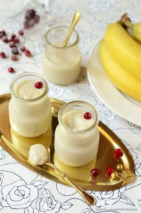 Two Small Jars Filled With Pudding Sitting On Top Of A Gold Plate Next To Bananas