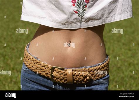 Woman Shows Her Bare Midriff With A Belly Button Ring While Wearing A