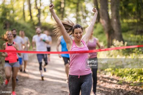 Female Runner Wining A Marathon Race And Crossing The Finish Line With