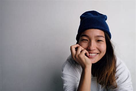 happy korean woman in hat smiling at camera del colaborador de