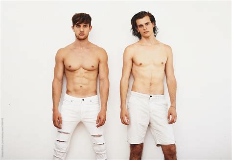 Two Male Models Posing Against White Wall By Stocksy Contributor