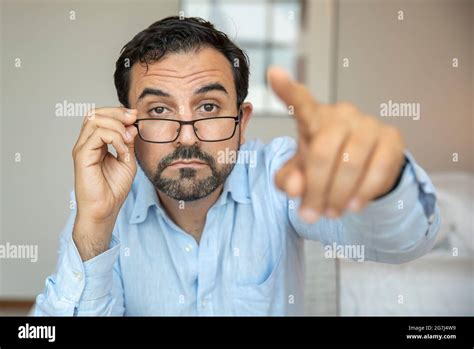 Man With A Poor Eyesight Trying To Adjust His Glasses To See Better
