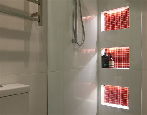 Gray marble grid tiled shower niche displayed over a thick marble floating bench around linear marble tiles and polished nickel shower kit. Shower Niche Lighting - Superlight