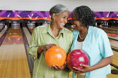 African Women Holding Bowling Balls In Bowling Alley Stock Photo