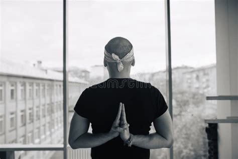 Man Practicing Yoga Meditation Pose Looking To The Street Through A