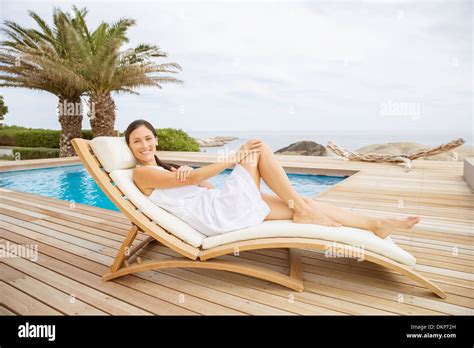 Woman Relaxing In Lounge Chair At Poolside Stock Photo Alamy