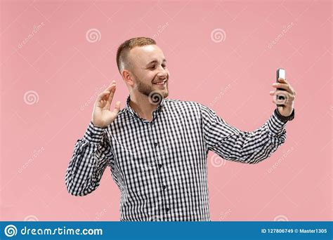 Portrait Of Attractive Young Man Taking A Selfie With His Smartphone Isolated On Pink