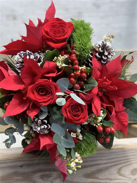 winter bouquet with roses pine cones hypericum berries and poinsettias winter bouquet