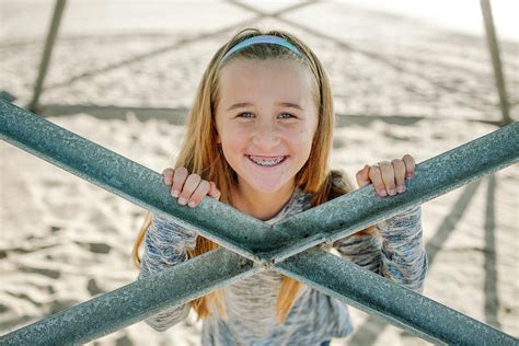 High Angle Portrait Of Cheerful Girl At Beach Below Lifeguard Hut
