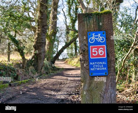 A Blue Metal Sign On A Wooden Post Shows The Route Of Uk National Cycle