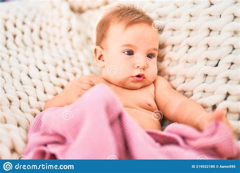 Adorable Baby Lying Down Over Blanket On The Sofa At Home Stock Photo