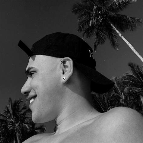 Black And White Photograph Of A Man Wearing A Hat With Palm Trees In