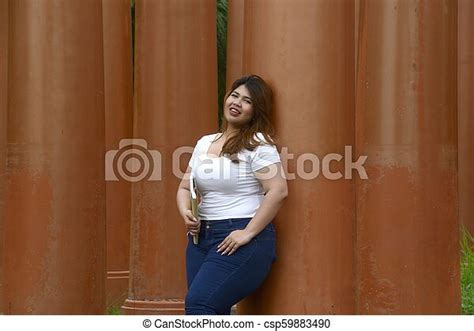 Portrait Of Asian Pretty Smiley Face Fat Woman Pose Standing And Hold A Booklet On Group Of Pole