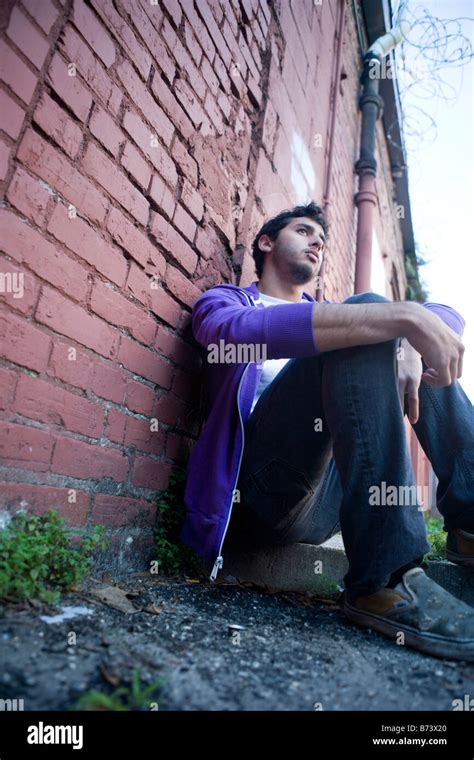Young Man Hanging Out In Alleyway Leaning Again Brick Wall Stock Photo