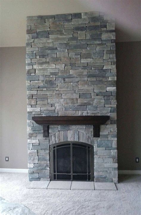 A Large Stone Fireplace In A Living Room With Carpeted Flooring And