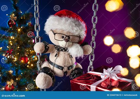 a teddy bear in a santa claus hat is a christmas t for bdsm games on the background of a