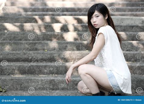 Cute Asian Woman In A White Top Squatting Down On Steps Stock Image Image Of Forward Clean
