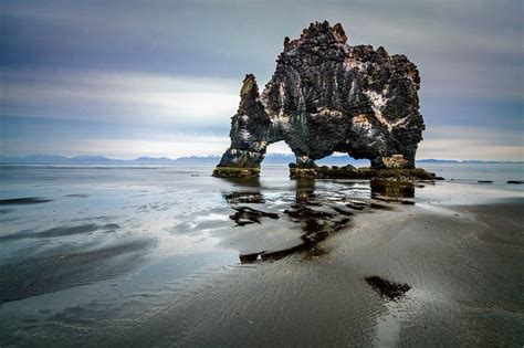 A Rock Formation In The Water On A Beach