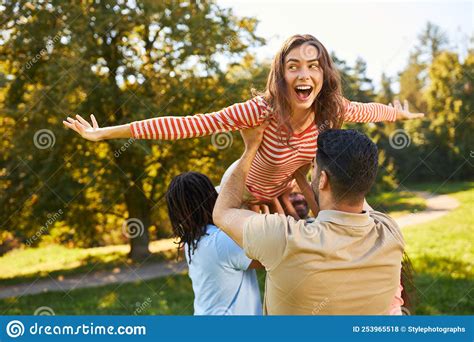 Group Of Young People Lifts Up Woman Together Stock Photo Image Of