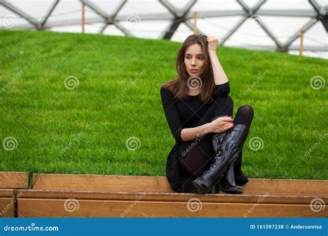 Young Beautiful Woman Sitting On A Bench In The Autumn Park Stock Photo