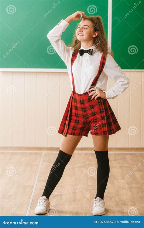 Beautiful Schoolgirl In Checkered Red School Uniform Standing In
