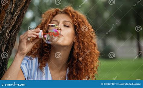 Curly Redhead Woman Blowing Soap Bubble Stock Image Image Of Hold Bright 240377407