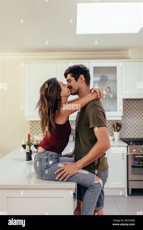 Affectionate Young Couple Together In The Kitchen At Home Couple In Love Kissing At Home Stock