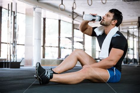 Fitness Man Sitting On The Floor And Drinking Water Royalty Free Stock