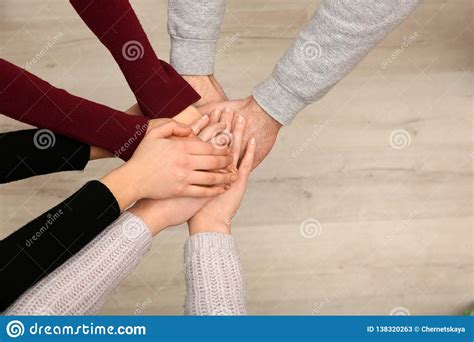 Young People Putting Their Hands Together Indoors Top View Stock