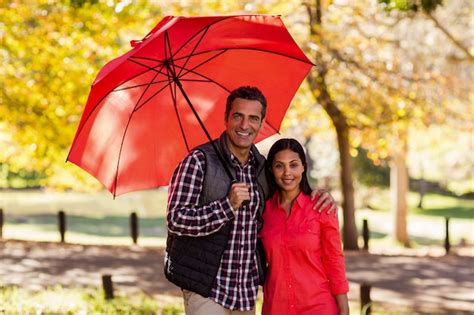 Premium Photo Portrait Of Couple Holding Umbrella
