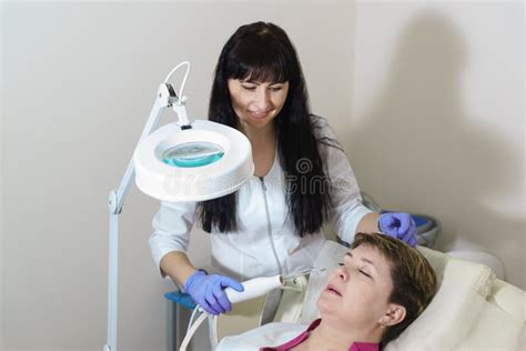A Beautiful Cosmetologist Conducts A Hardware Procedure To The Patient