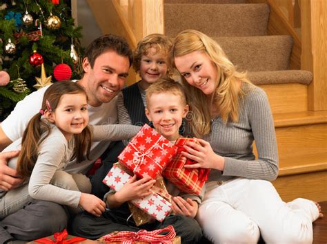 Best christmas gifts for the family. Family With Gifts In Front Of Christmas Tree Stock Photo ...