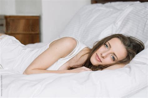 Beautiful Calm Girl Lying On White Bed Del Colaborador De Stocksy
