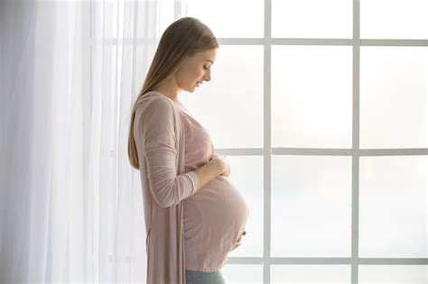 Mujer Embarazada Joven Esperando Un Padre Feliz Bebé Cerca De La Ventana Foto Premium