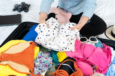 premium photo woman preparing and packing clothes into suitcase on a bed at home holiday