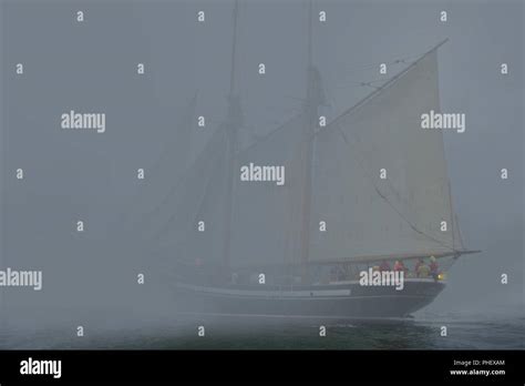 Two Masted Schooner With Sails On Port Side Tack Sails Into Dense Fog