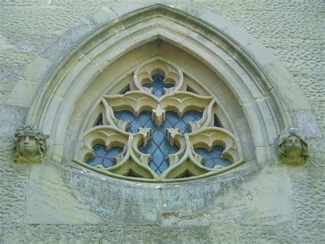 An Ornate Window In The Side Of A Stone Building With Blue And Yellow