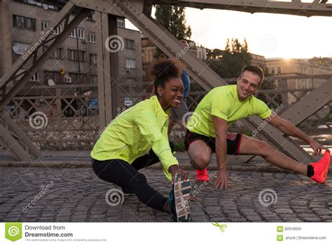 Jogging Couple Warming Up And Stretching In The City Stock Photo