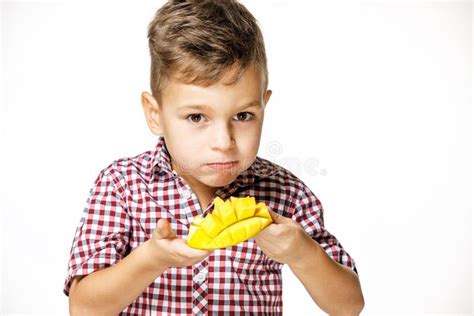 Handsome Boy In A Red Shirt Is Eating A Mango Stock Image Image Of