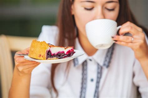 Jeune Belle Fille Heureuse Prenant Le Petit Déjeuner Café Et Cheesecake Assis à La Table Photo