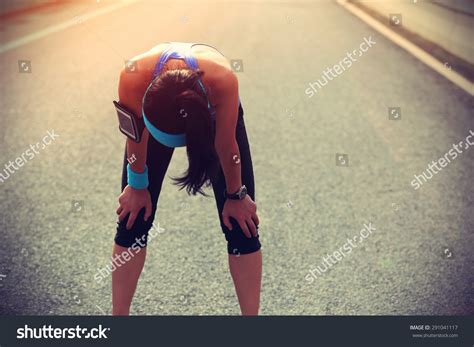 Tired Woman Runner Taking A Rest After Running Hard On City Road Stock