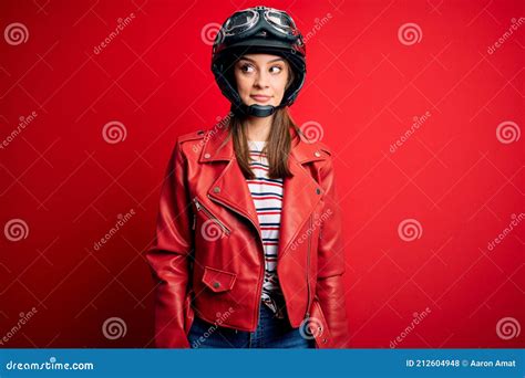 Young Beautiful Brunette Motocyclist Woman Wearing Motorcycle Helmet And Red Jacket Smiling