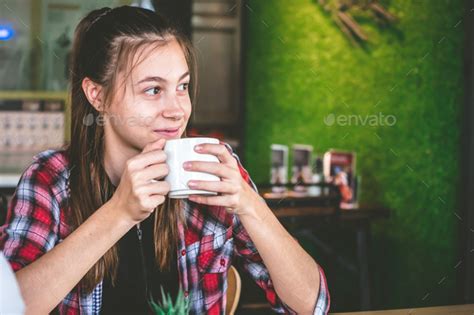 Beautiful Girl Drinking Coffee In Cafe While Thinking And Looking