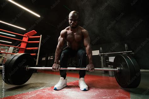 Muscular African American Man Lifts A Heavy Barbell For Powerlifting